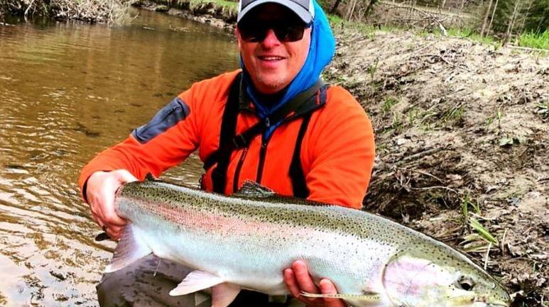 John with fish in stream